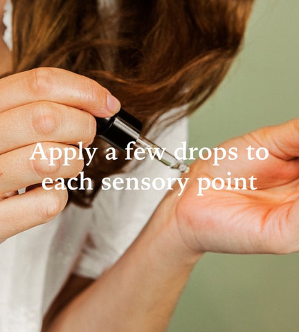 A woman applying lavender oil drops to her hand