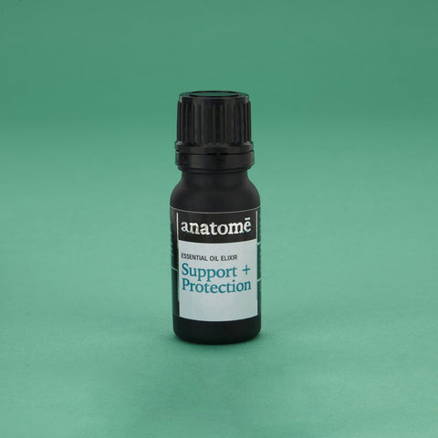 Essential oil for support in a black bottle on a green backdrop