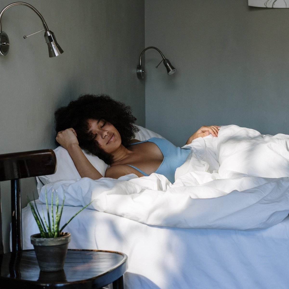 A woman waking up happy in her bed